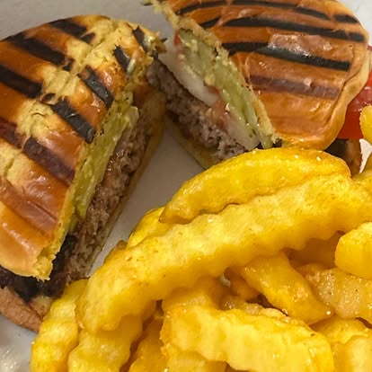 Grilled panini halves with crinkle-cut fries.