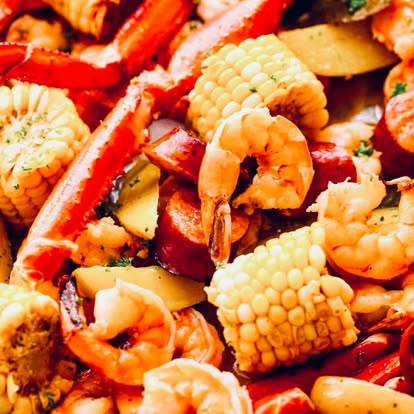 Close-up of boiled shrimp and corn cobs.