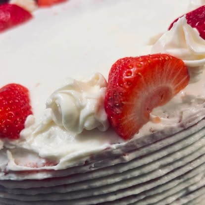 A cake slice topped with strawberries and cream.