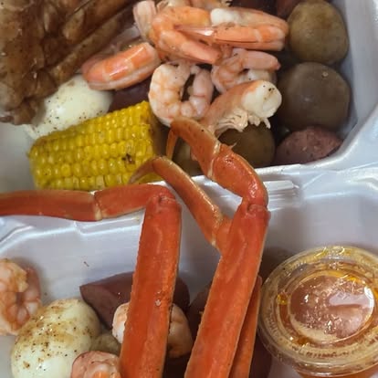 A seafood boil tray with shrimp, corn on the cob and potatoes.