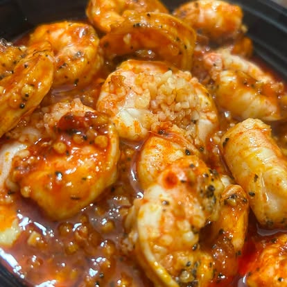 Shrimp in sauce in a skillet, close-up.